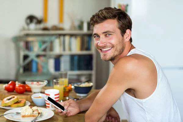 Joven sonriente usando teléfono móvil — Foto de Stock