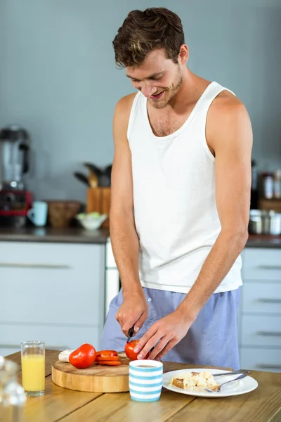 Homem feliz cortando legumes — Fotografia de Stock