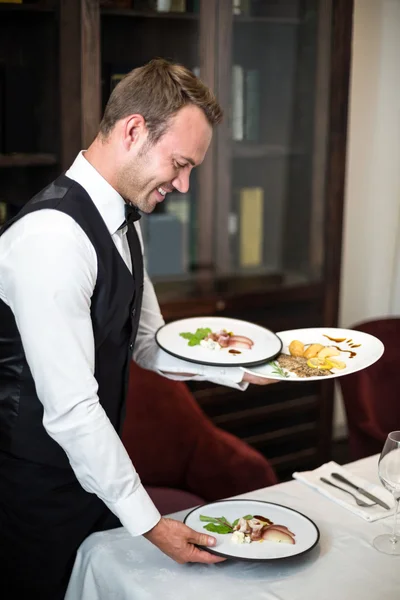 Handsome waiter serving meal — Stock Photo, Image