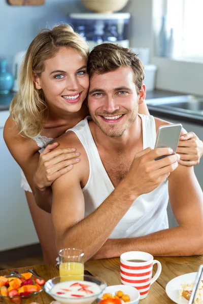 Žena s mužem drží mobilní telefon — Stock fotografie