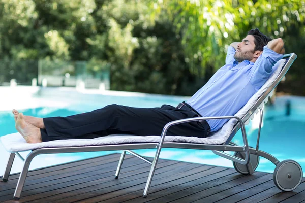 Smart man relaxing on sunlounger — Stock Photo, Image