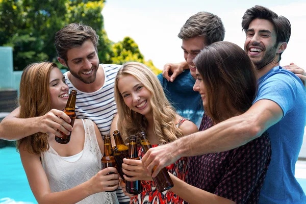 Gruppe von Freunden prostet Bierflaschen in der Nähe des Pools zu — Stockfoto