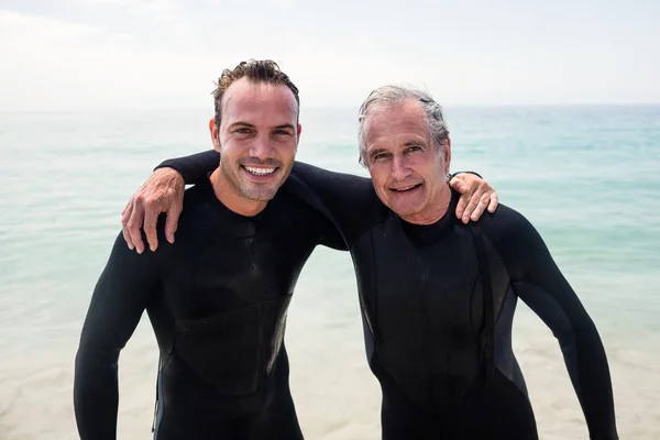 Pai e filho de fato de mergulho abraçando — Fotografia de Stock