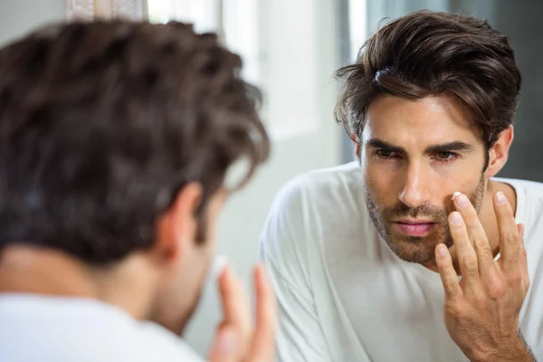 Homme appliquant une crème hydratante sur le visage — Photo