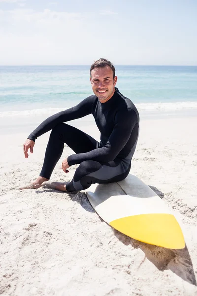 Surfer in wetsuit met surfboard op strand — Stockfoto
