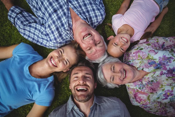 Family forming huddle on field — Stock Photo, Image