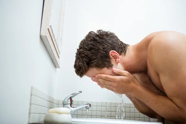 Mann wäscht sich im Badezimmer das Gesicht — Stockfoto