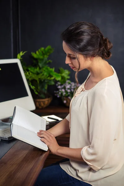 Kobieta interesu czytanie notebooka na biurko — Zdjęcie stockowe