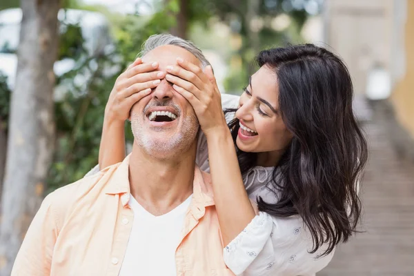 Cheerful woman covering eyes of man — Stock Photo, Image