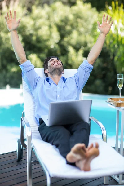 Hombre usando el ordenador portátil cerca de piscina — Foto de Stock