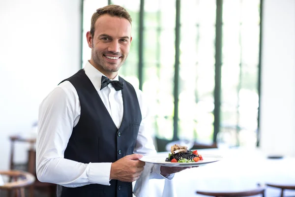 Waiter showing dish — Stock Photo, Image