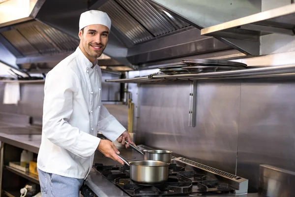 Chef bonito olhando para panelas — Fotografia de Stock