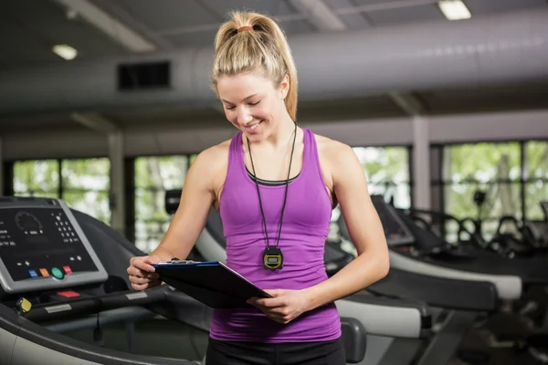 Trainer schaut auf Klemmbrett — Stockfoto