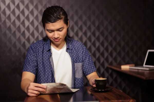 Mann liest Zeitung und trinkt Kaffee — Stockfoto