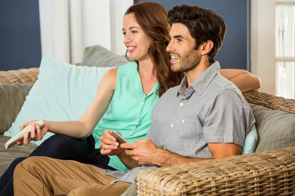 Couple regardant la télévision sur le canapé — Photo