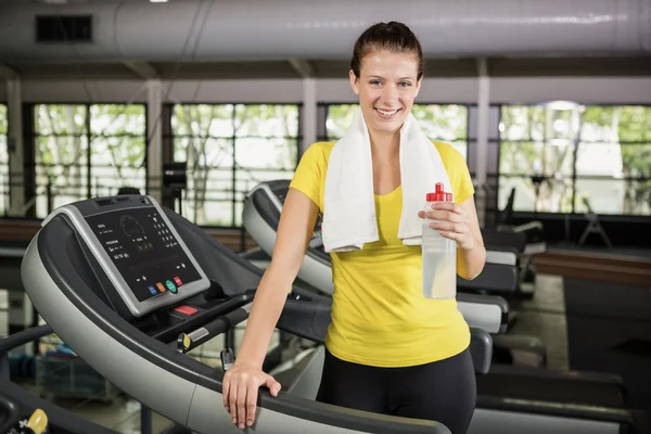 Woman standing on treadmill with water — Stock Photo, Image