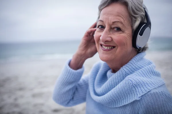 Senior vrouw luisteren naar muziek — Stockfoto