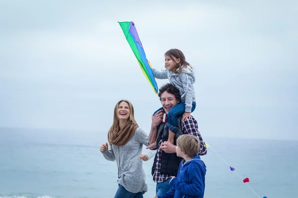 Familj med kite njuter till sjöss shore — Stockfoto