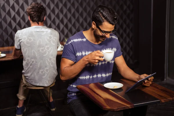 Homme utilisant une tablette et buvant du café — Photo