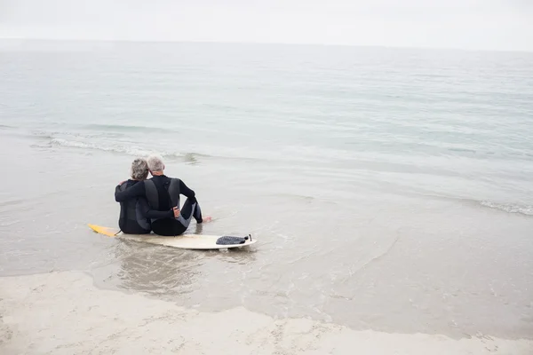 Couple sitting on surfboard — Stock Photo, Image