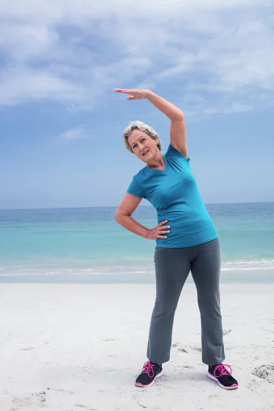 Mujer mayor haciendo ejercicio en la playa — Foto de Stock