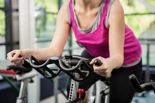 Woman working out on exercise bike — Stock Photo, Image