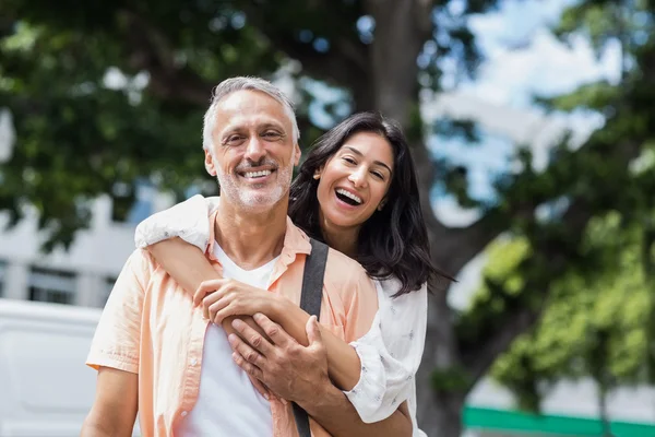 Happy woman hugging man from behind — Stock Photo, Image