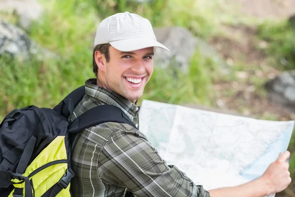 Uomo con mappa su roccia — Foto Stock