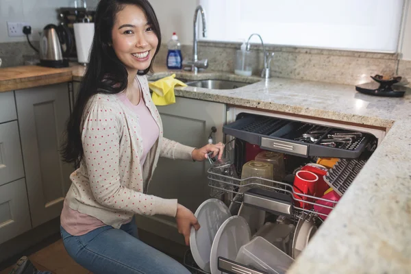 Femme arrangeant des assiettes en lave-vaisselle — Photo
