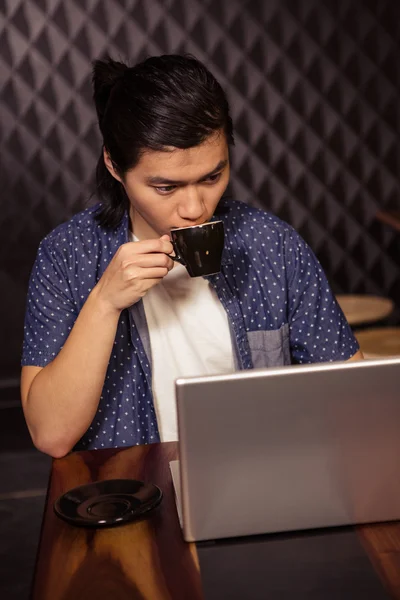 Mann benutzt Laptop und trinkt Kaffee — Stockfoto