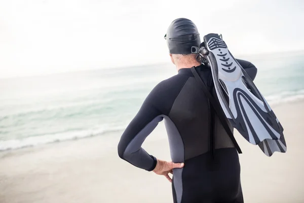 Äldre man med flipper stående på stranden — Stockfoto