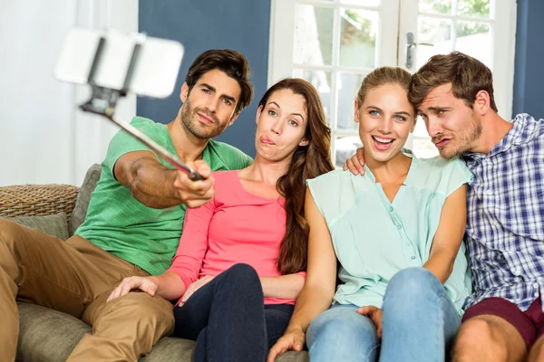 Vrienden maken van gezichten houdend selfie — Stockfoto