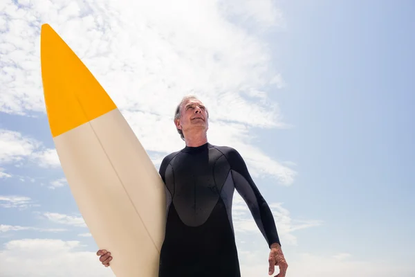 Senior man in wetsuit holding surfboard — Stock Photo, Image