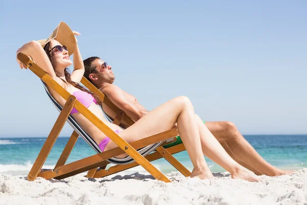 Casal relaxante em cadeiras deck — Fotografia de Stock