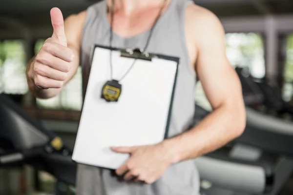 Tränare visar sina tummar på gym — Stockfoto