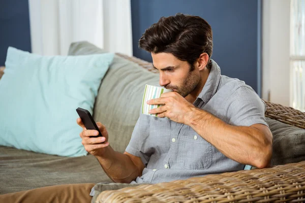 Man att ha kaffe med telefonen — Stockfoto