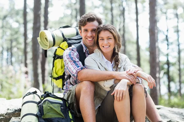 Sorridente coppia seduta sulla roccia — Foto Stock