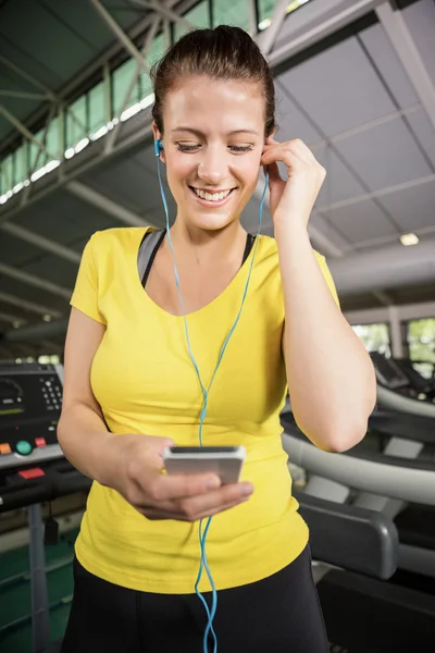 Woman listening to music on treadmill — Stock Photo, Image