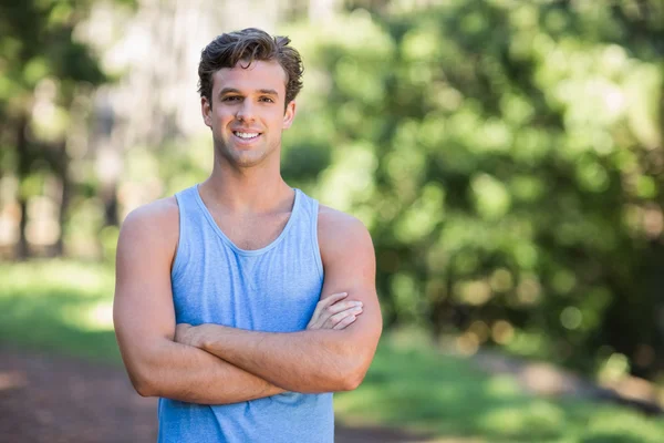 Sonriente hombre de pie en el bosque — Foto de Stock