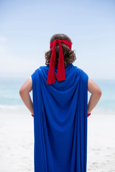 Niño en traje de superhéroe en la orilla del mar — Foto de Stock