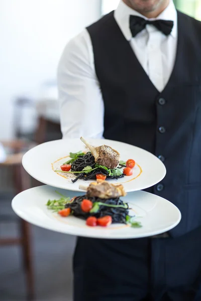 Camarero mostrando plato — Foto de Stock