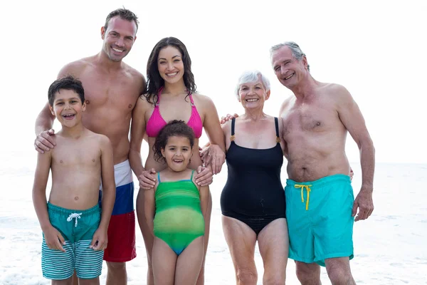 Uśmiechnięta rodzina stojący na plaży — Zdjęcie stockowe