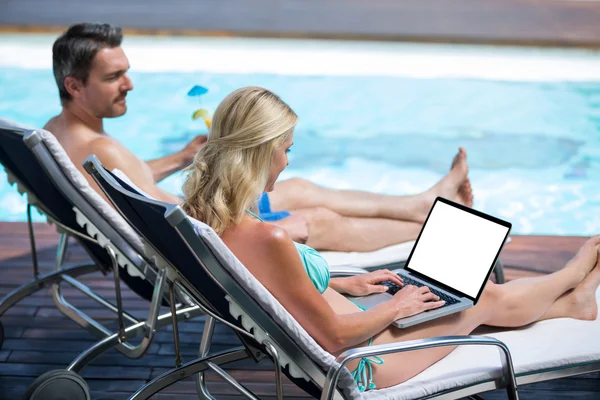 Couple assis sur une chaise longue près de la piscine — Photo