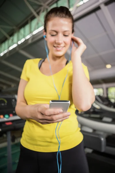 Donna che ascolta musica sul tapis roulant — Foto Stock