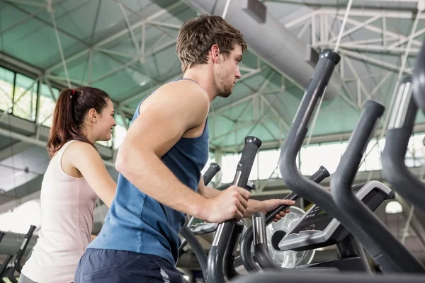 Frau und Mann beim Training auf einem Crossgerät — Stockfoto