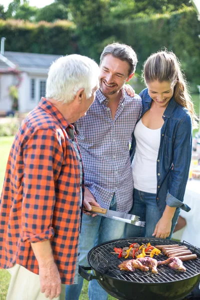 Ehepaar bereitet mit Senior Essen zu — Stockfoto