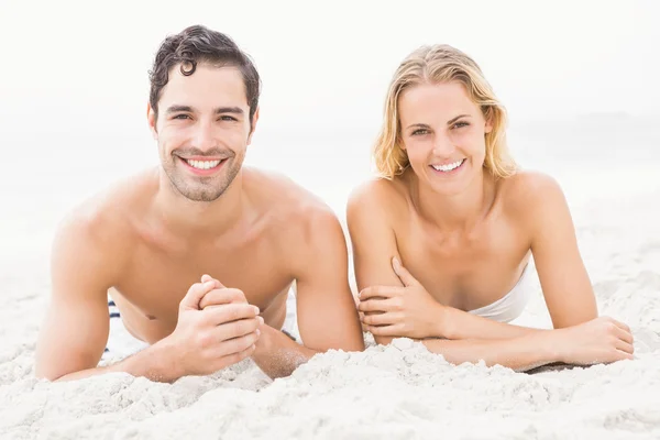 Pareja feliz acostada en la playa — Foto de Stock