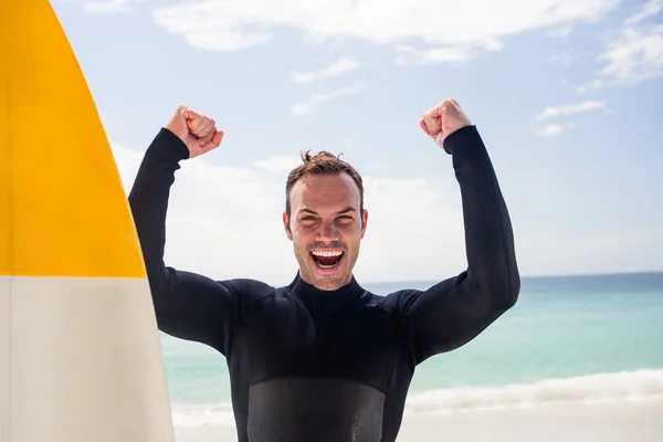 Uomo con tavola da surf in piedi sulla spiaggia — Foto Stock