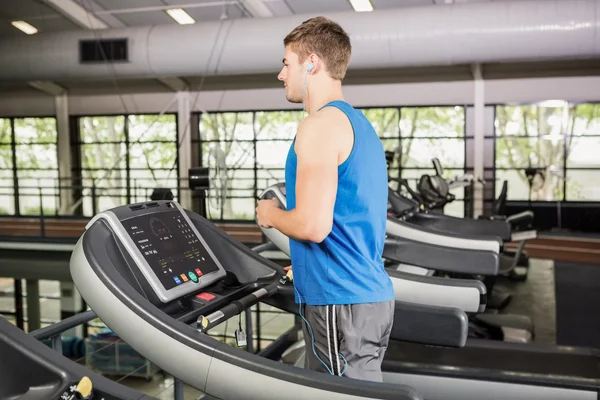 Hombre en la cinta de correr escuchando música — Foto de Stock