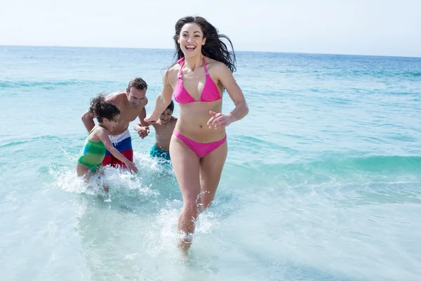 Woman running against family — Stock Photo, Image